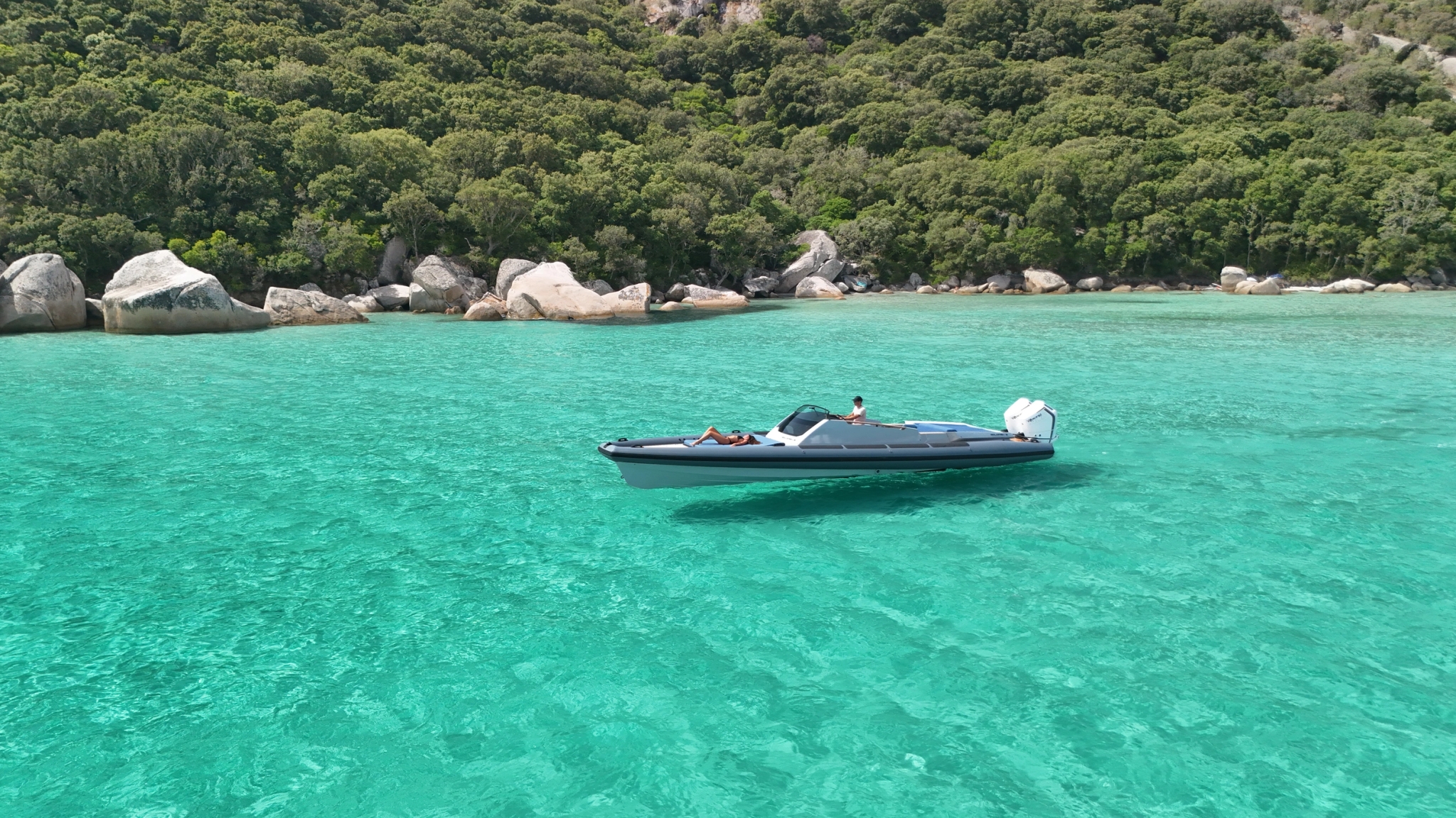 Location bateau dans une baie tropicale aux eaux turquoise et roches granitiques