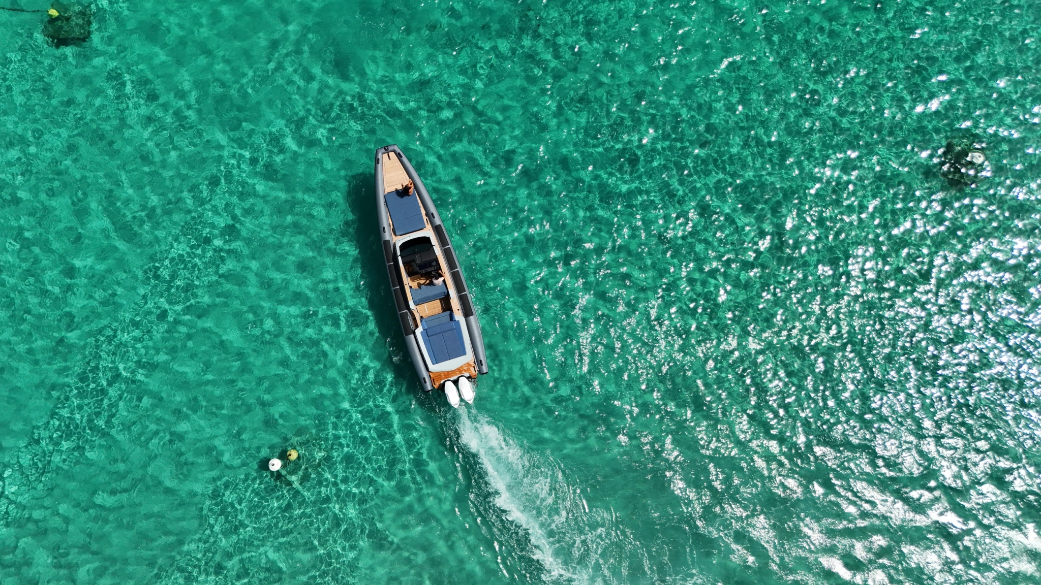 Location de bateau moderne amarré en eaux turquoise cristallines vue aérienne