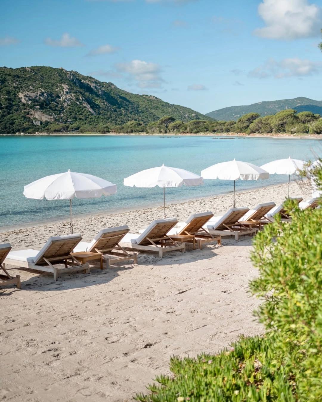 Restaurant en bord de mer à Santa Giulia avec transats et parasols blancs