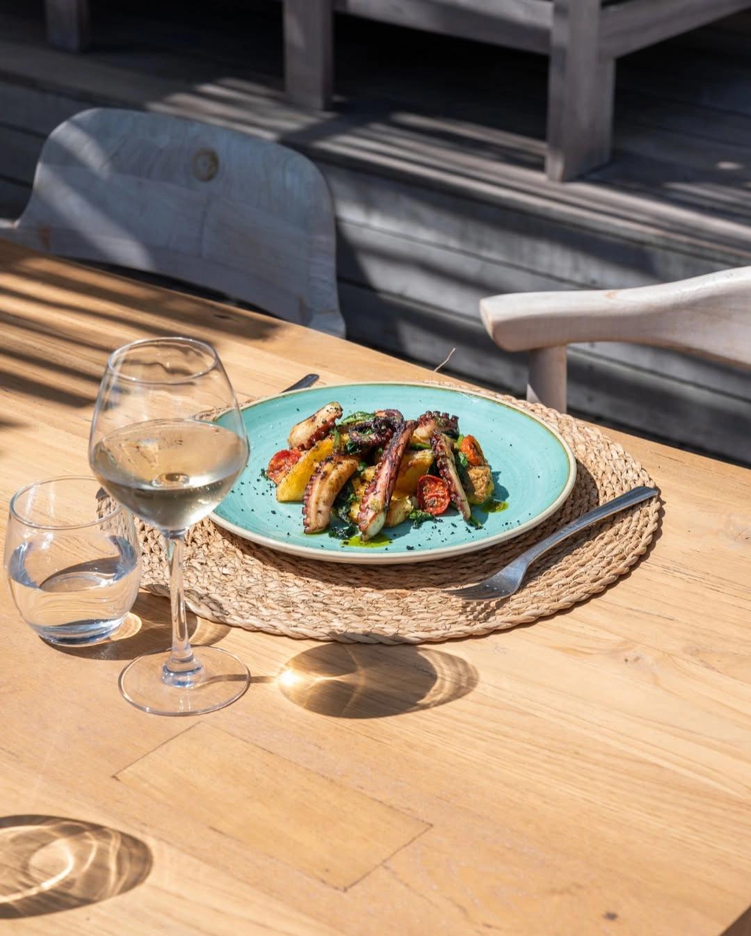Assiette de saucisses grillées et légumes sur la carte du restaurant de plage à Santa Giulia