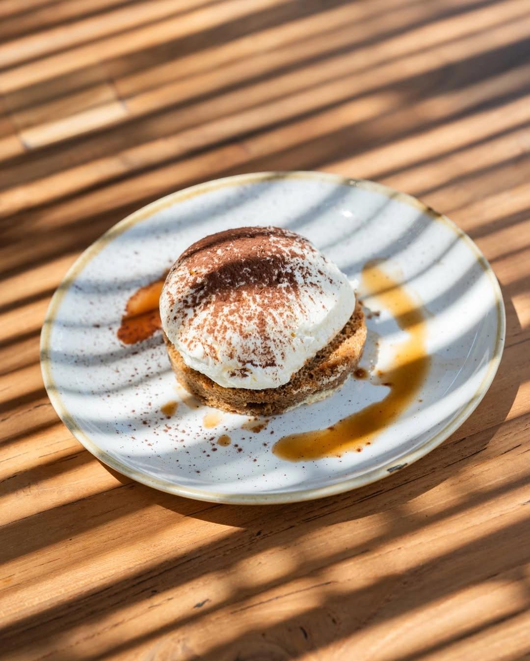 Dessert tiramisu présenté dans un restaurant de plage à Santa Giulia