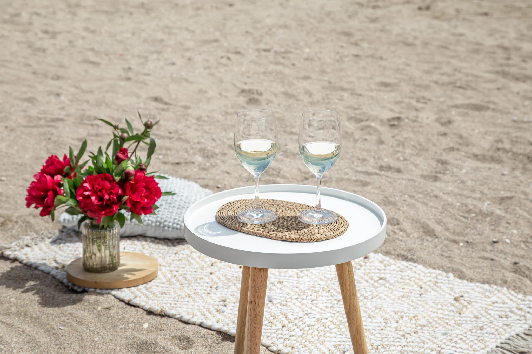 Table ronde blanche avec verres d'eau et décoration florale pour mariage et événements privés à Santa Giulia
